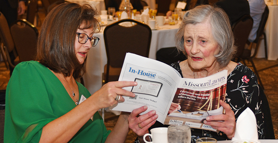 Jo Ann Buettner and her mother Mary Ann Let look at the November issue of Missouri Lawyers Weekly