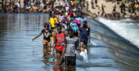 Migrants are shown crossing the U.S.-Mexico border in 2021