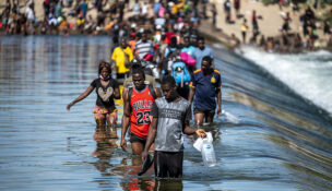 Migrants are shown crossing the U.S.-Mexico border in 2021