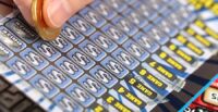 A human hand is scratching a lottery ticket